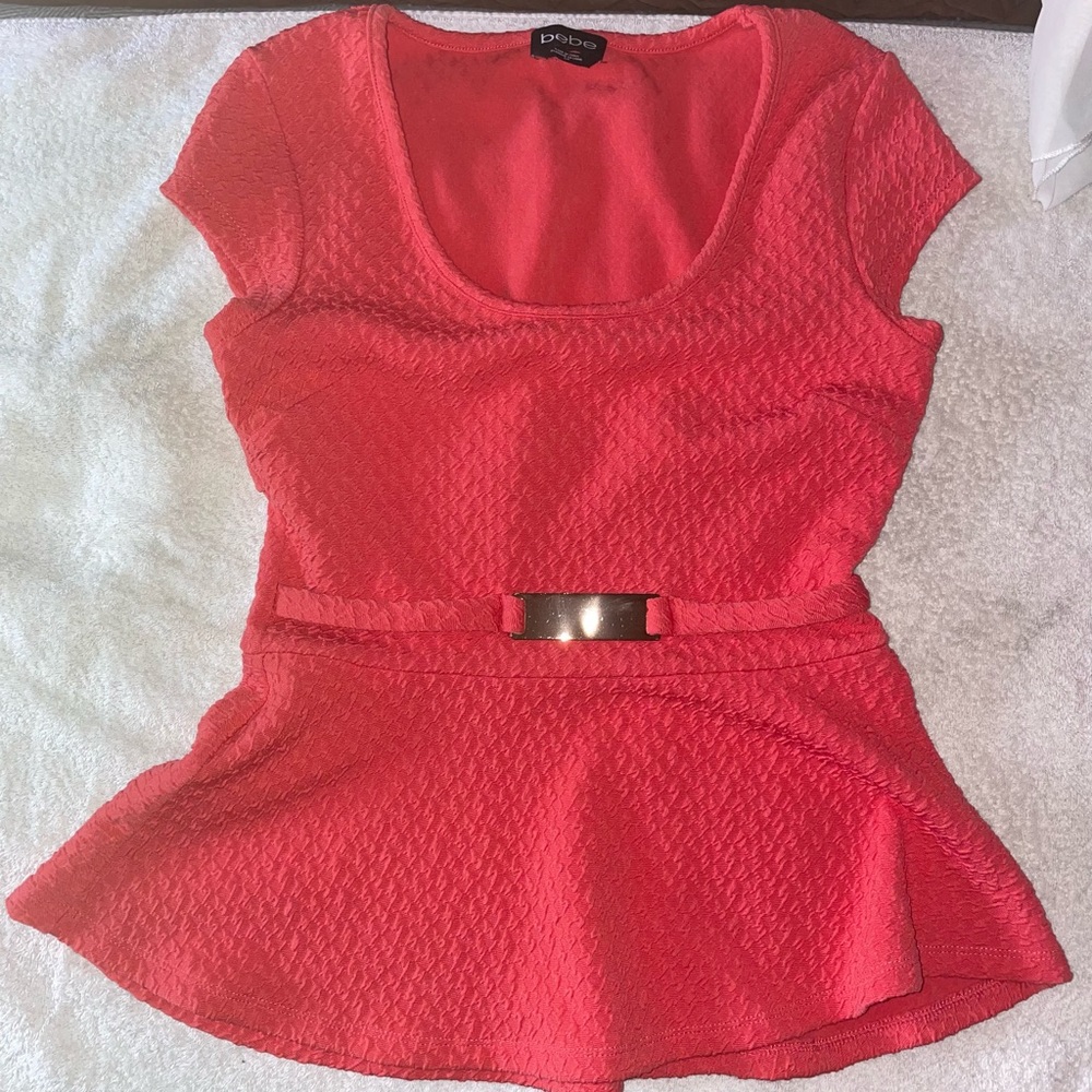 BEBE Coral peplum top with keyhole in back and buckle accent